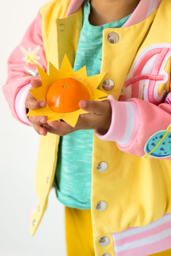 A person holding an orange