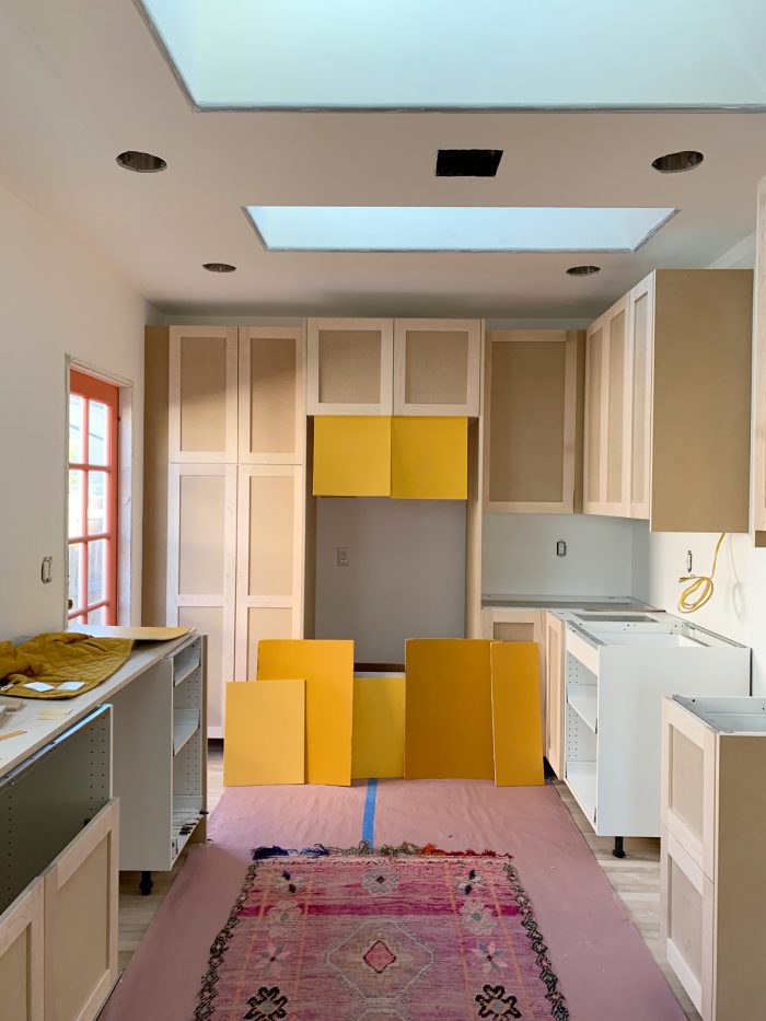 A kitchen with yellow paint samples