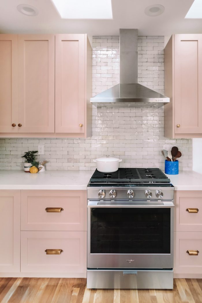 A kitchen with pink cabinets