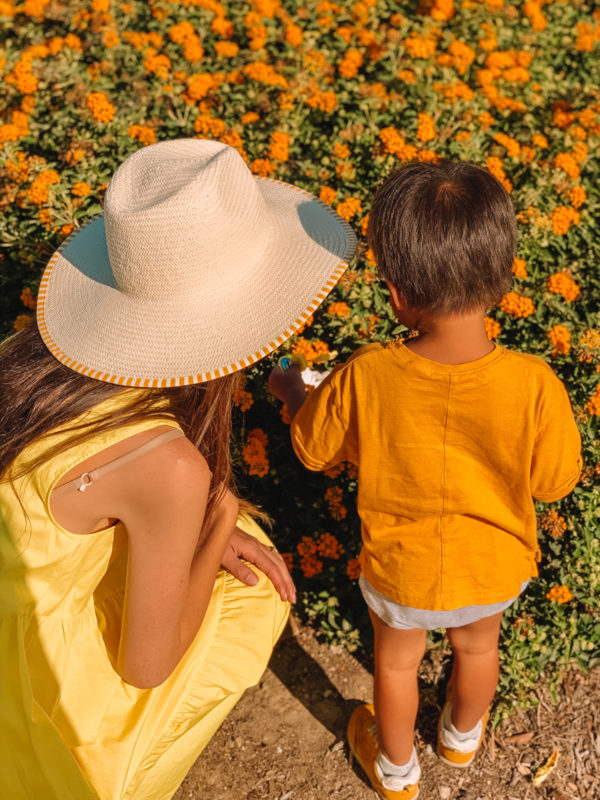 A woman wearing a hat and a little boy wearing orange