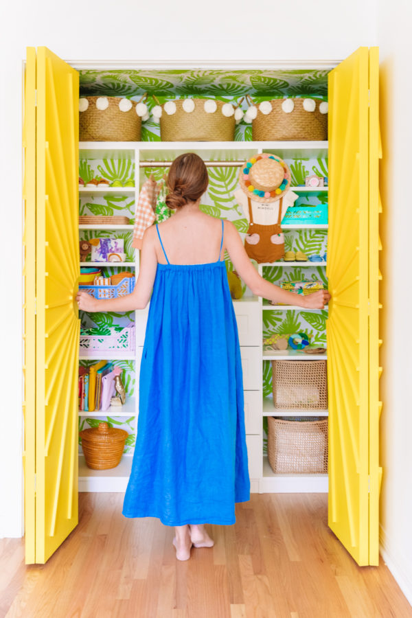 A little girl standing in front of a closet