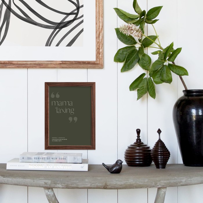 Table with black vase and green art print on wall
