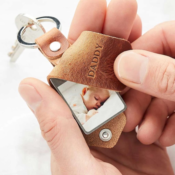 hand holding leather keychain with baby photo in it
