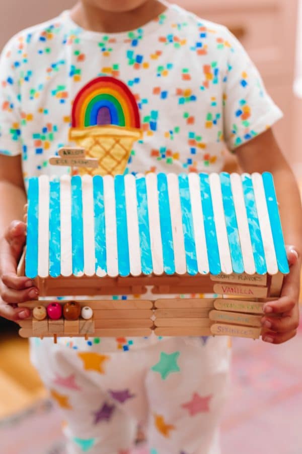 A person holding a popsicle house