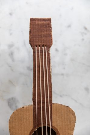 A close up of a cardboard guitar