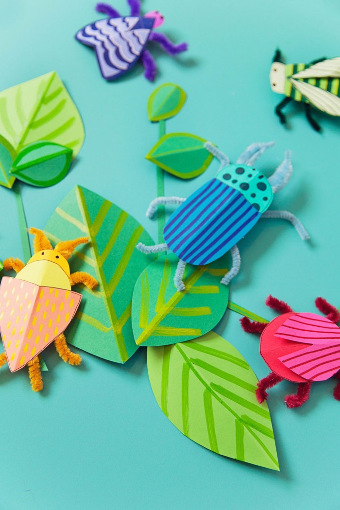 Paper bug crafts on table.