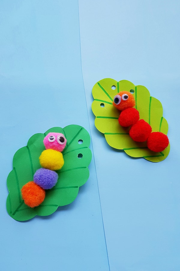 Pom pom caterpillar crafts on a table.