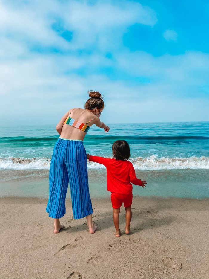 A boy and a woman standing on a beach