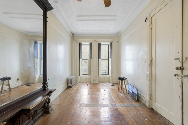 A room with a wooden floor and windows