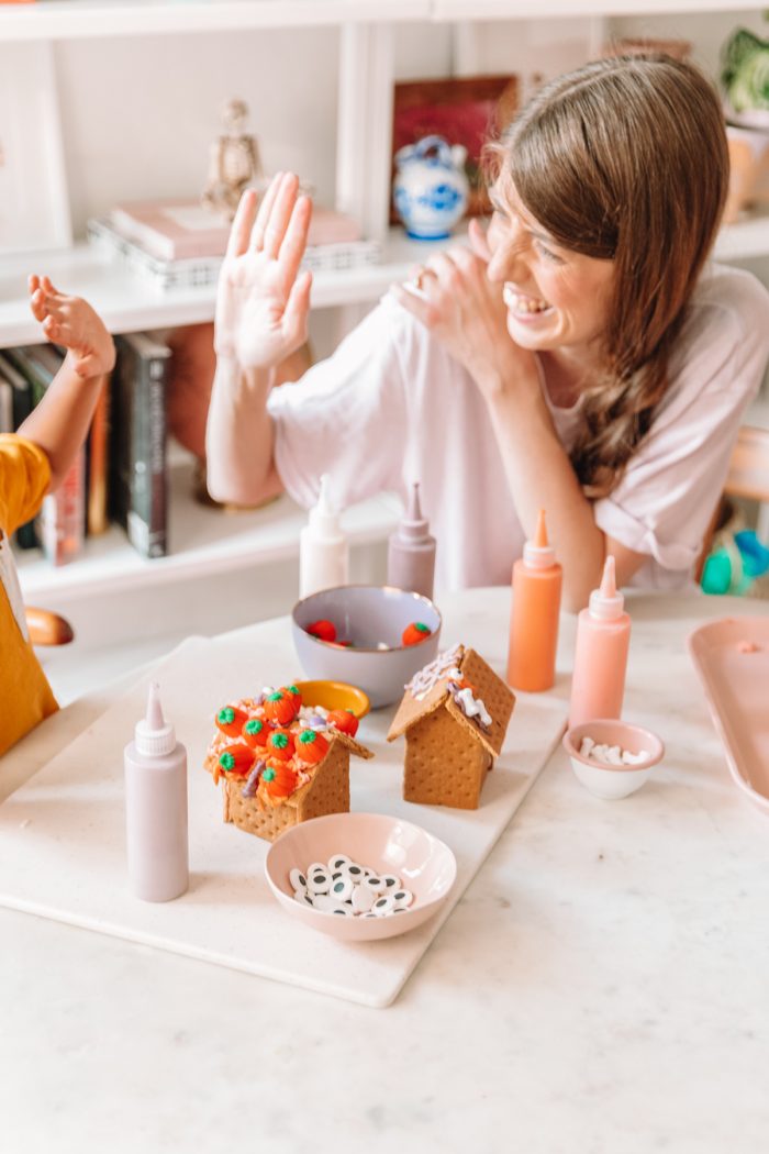 Someone sitting at a table making graham cracker houses