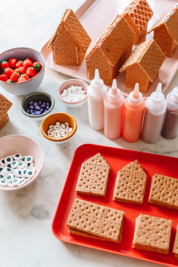 A tray of graham crackers with frosting and toppings on the side