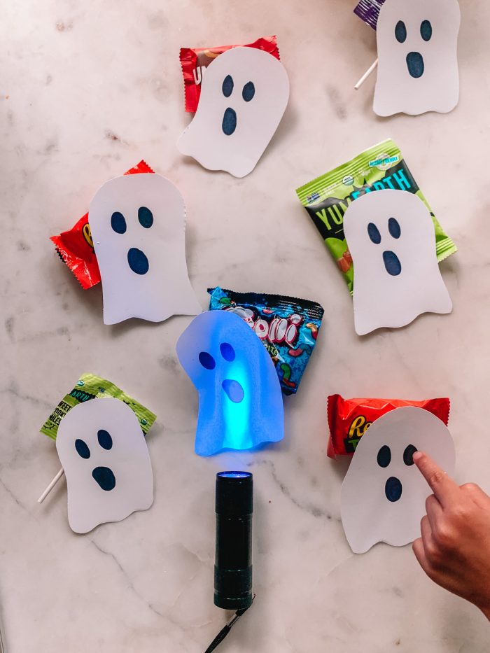 A group of paper ghosts and candy on a table