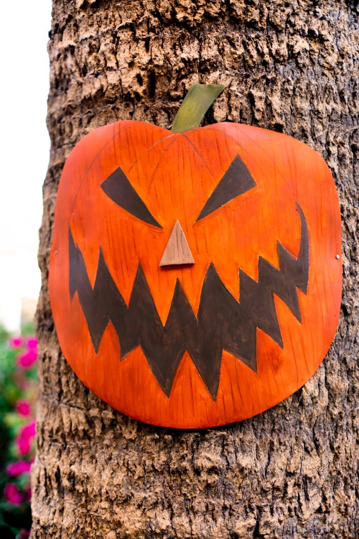 A pumpkin decoration on a palm tree