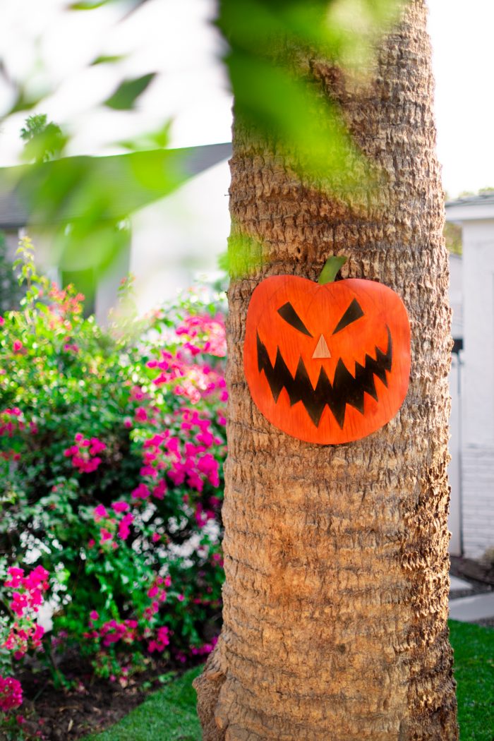 A pumpkin decoration on a palm tree