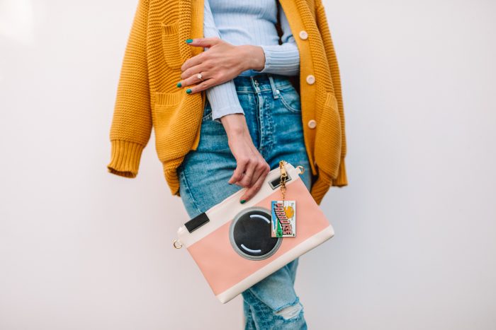 A person holding a camera cluth bag