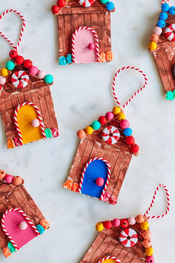 Popsicle stick gingerbread house ornaments on a table