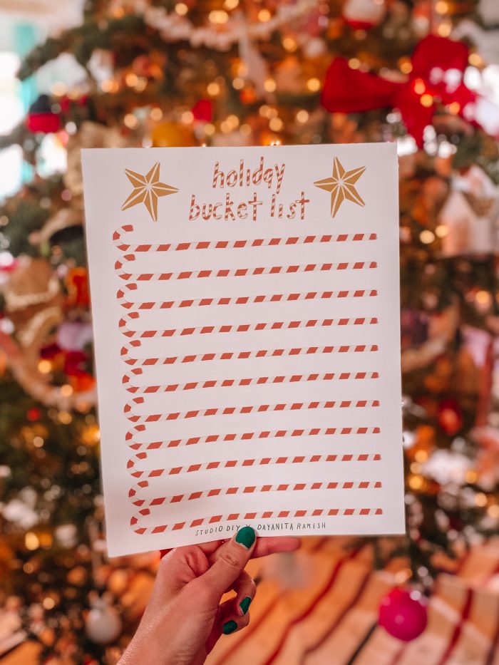 Hand holding a piece of paper with candy canes printed on it. 