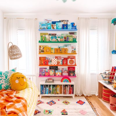 A bedroom with rainbow shelves