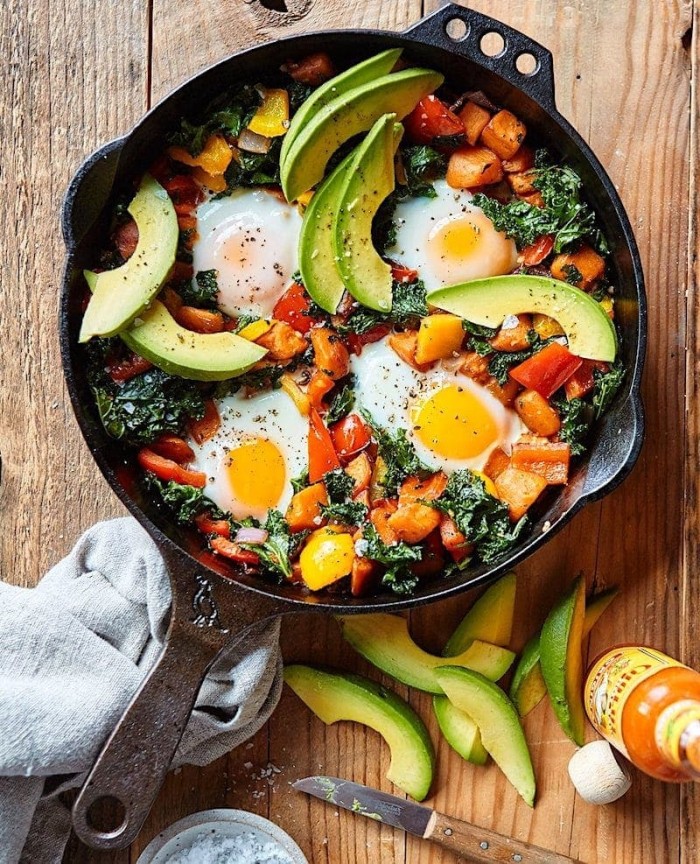 Sweet Potato Hash in a cast iron skillet on a wood board