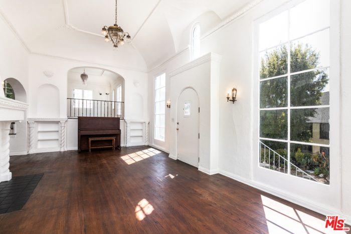 A living room with white walls and wood floors