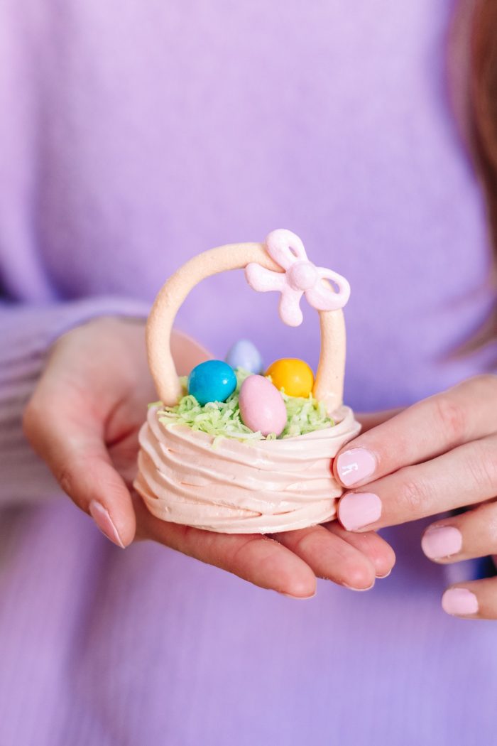 A hand holding a small easter basket