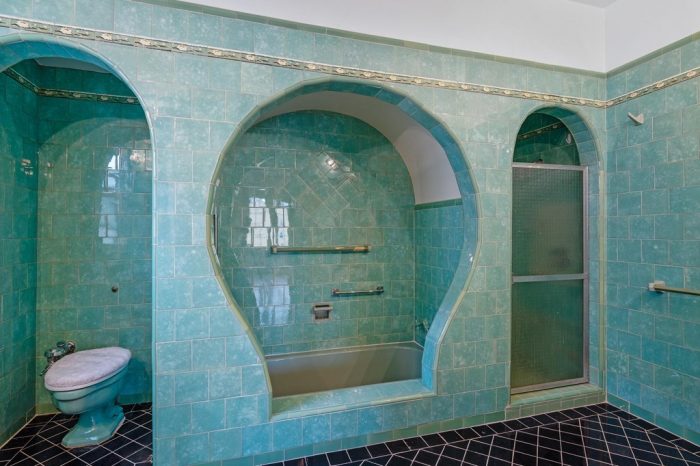 A blue-tiled bathroom with a tub