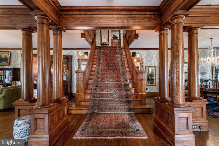 A wooden staircase with a rug