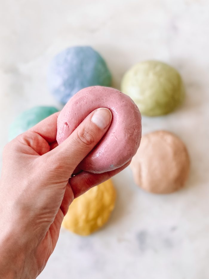 A close up of a hand holding play dough