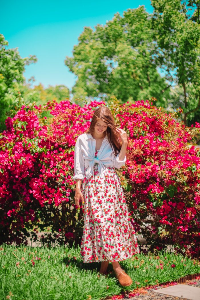 A woman standing in front of flowers