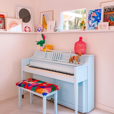 Blue Piano with colorful bench and art ledge behind it
