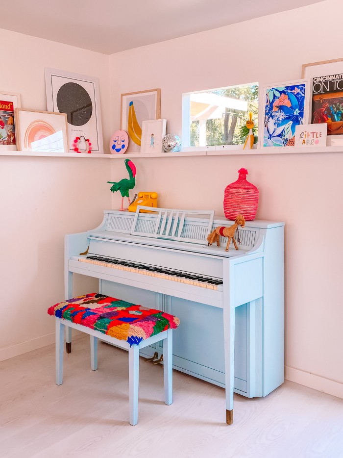 Blue Piano with colorful bench and art ledge behind it