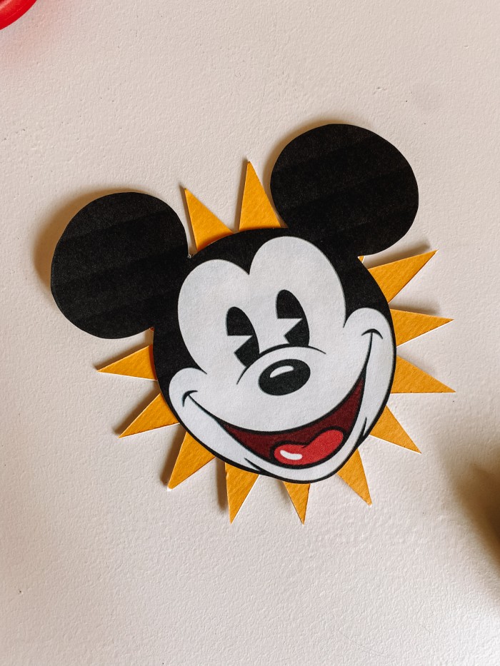 Mickey face on a yellow sunburst on a white table