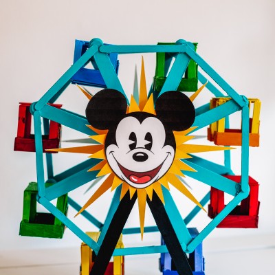 Popsicle stick Ferris wheel decorated like the Pixar Pal-A-Round from Disney's California Adventure on a white table