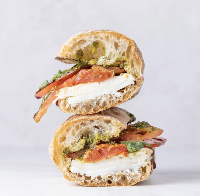 Caprese sandwich stacked on a white background