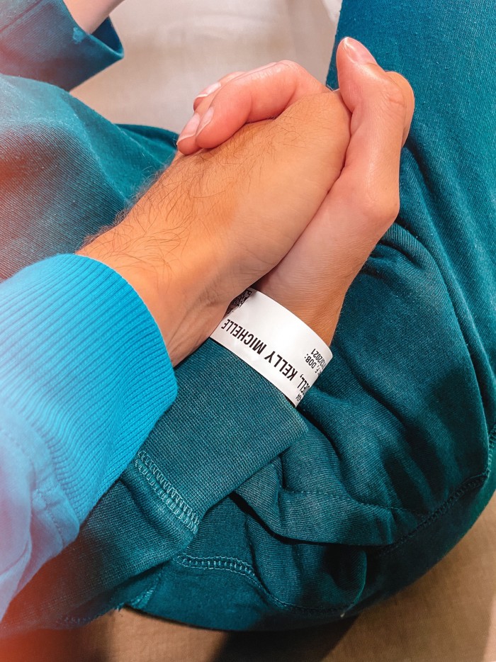 Hand holding with hospital wristband on one wrist