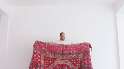 Vintage Fuchsia Moroccan Rug held in front of a white wall