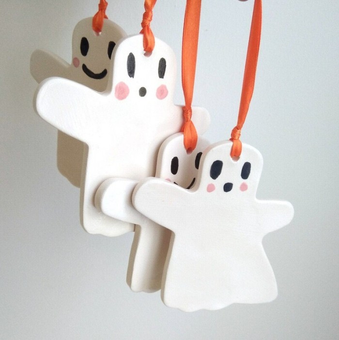 ceramic ghost ornaments hanging against a white wall