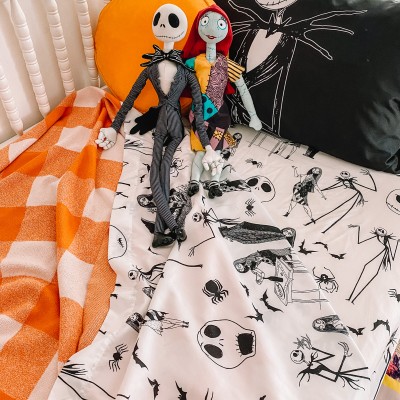 Nightmare before christmas sheets on bed with stuffed animals and plaid blanket