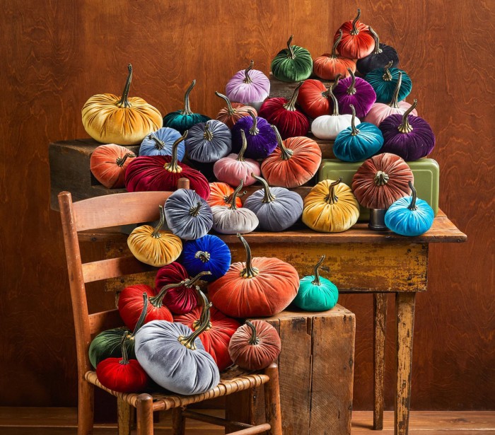 velvet pumpkins in rainbow colors on table and chair