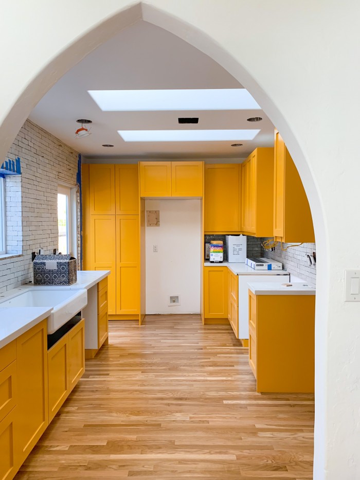 Yellow orange kitchen cabinets with wood floor