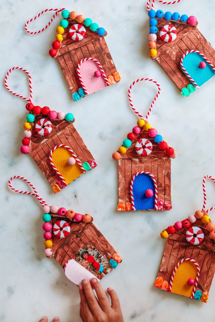 Gingerbread popsicle stick ornaments scattered on a marble table. 