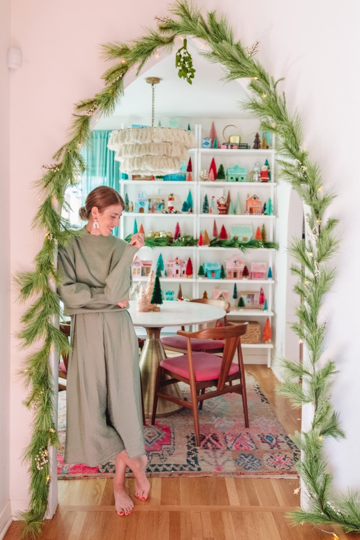 Woman standing in archway with Christmas garland