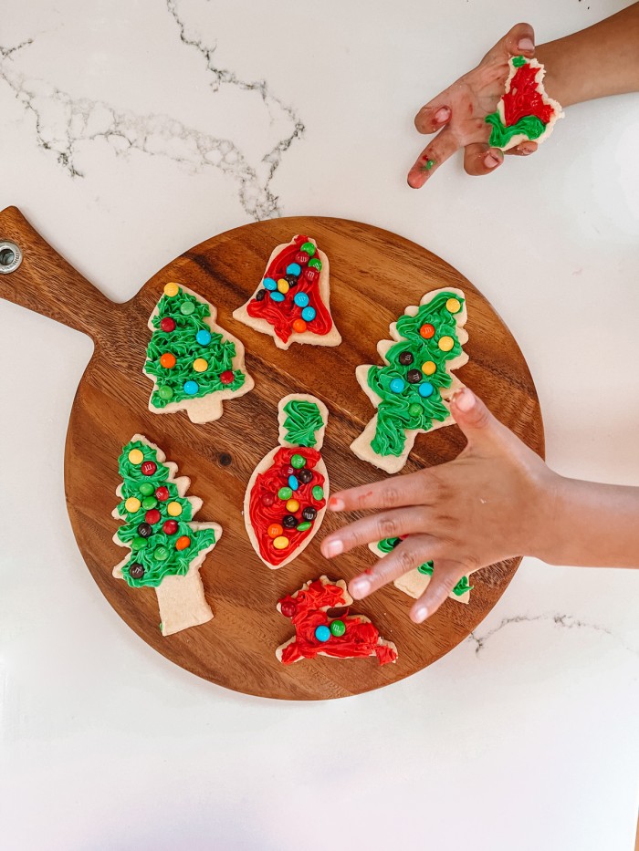 Christmas cookies on plate with child's hand reaching in