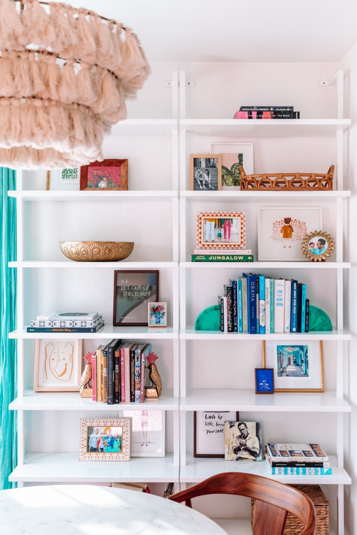 Books, art and bowls on white bookshelves