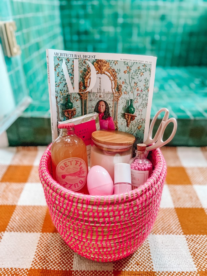 pink Easter basket filled with magazine, candle and scissors