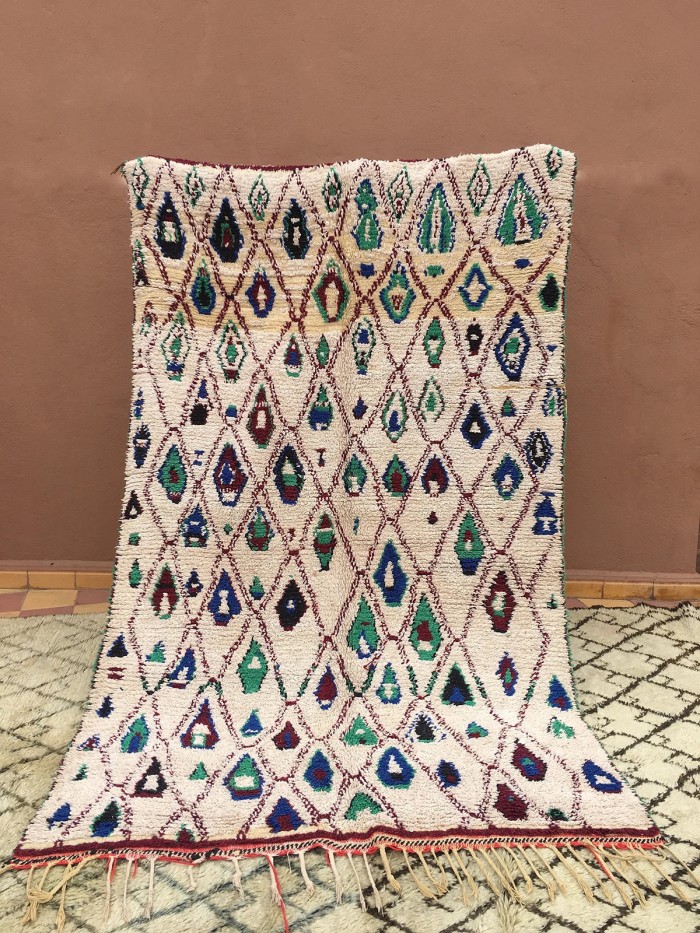 blue and teal patterned rug against wall