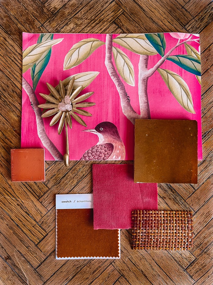 pink wallpaper and tile samples on wood table