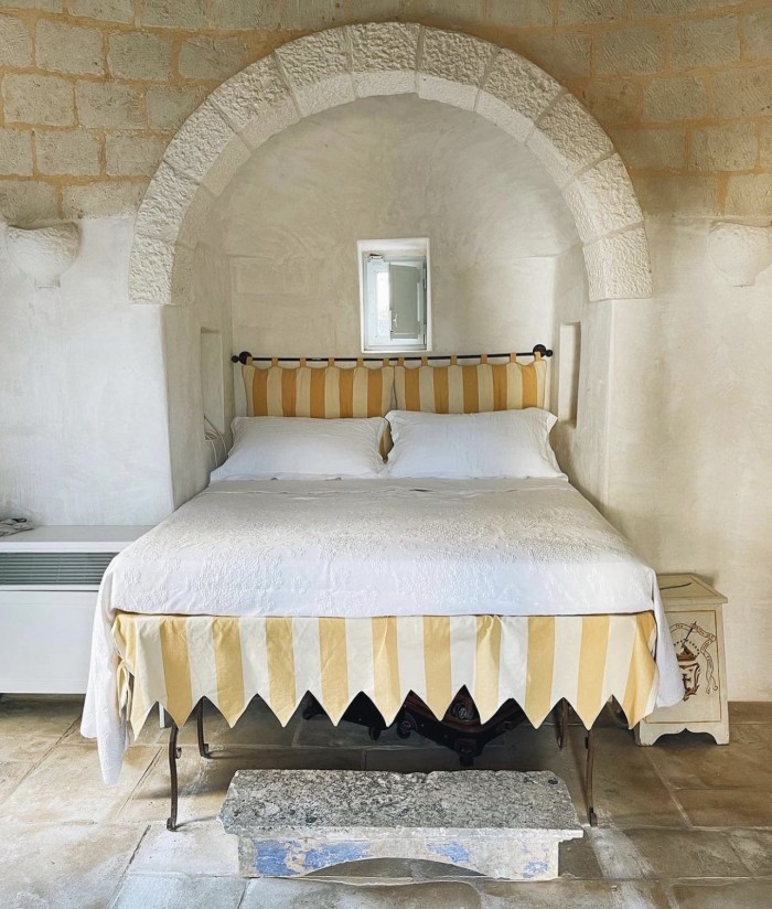 white bed with yellow stripe headboard