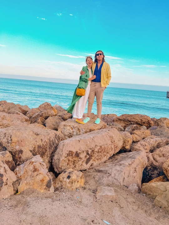 Couple standing on rocks in front of ocean
