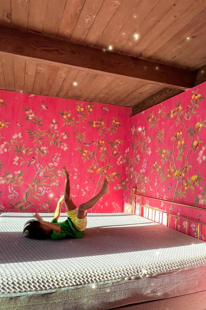 child jumping on mattress in pink bedroom